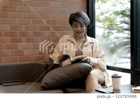adult woman is sitting comfortably in a cozy corner 122785990