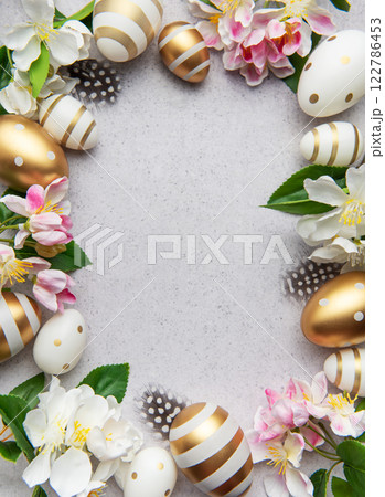 Elegant easter arrangement with golden eggs and blossoms 122786453