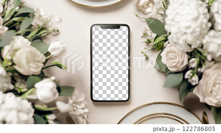 花のテーブルセッティングにスマートフォンを置いたミニマリストな結婚式招待状のモックアップ 122786805