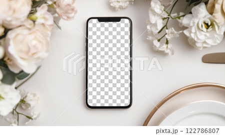 花のテーブルセッティングにスマートフォンを置いたミニマリストな結婚式招待状のモックアップ 122786807