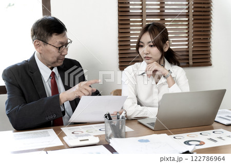 A manager or coach is coaching an assistant young businesswoman A manager or coach is coaching an assistant young businesswoman 122786964