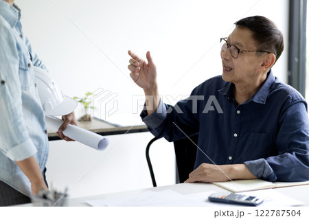 Architect or engineer are discussing and consulting in the office 122787504