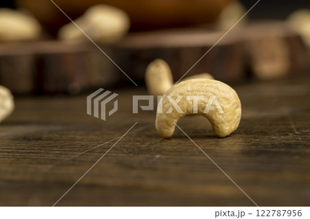 large cashew nuts are scattered on a larch board large cashew nuts are scattered on a larch board 122787956