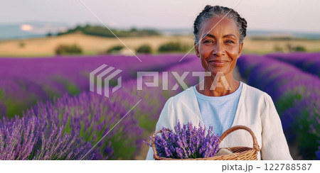 banner with an elderly lady with a basket of handmade soap against the background of a blooming lavender field, copy space about cosmetics from natural oils and herbs 122788587