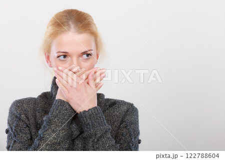 Shocked woman holding hand on lips Shocked woman holding hand on lips 122788604