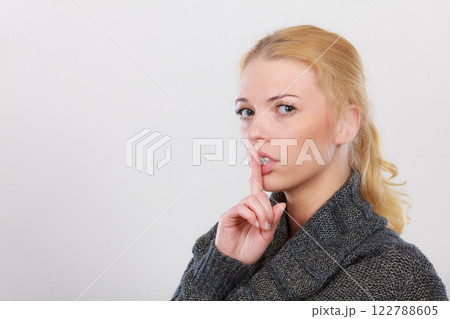 Woman holding finger close to lips, silence Woman holding finger close to lips, silence 122788605