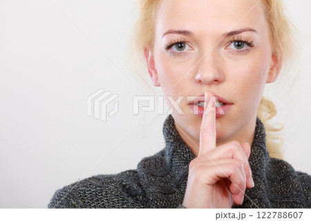 Woman holding finger close to lips, silence Woman holding finger close to lips, silence 122788607