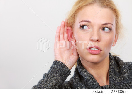 Woman put hand to ear for better hearing Woman put hand to ear for better hearing 122788632