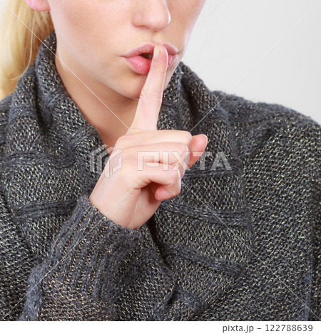 Woman holding finger close to lips, silence Woman holding finger close to lips, silence 122788639