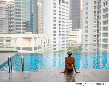 Young woman relaxing by the pool at a Kuala Lumpur hotel Young woman relaxing by the pool at a Kuala Lumpur hotel 122788814