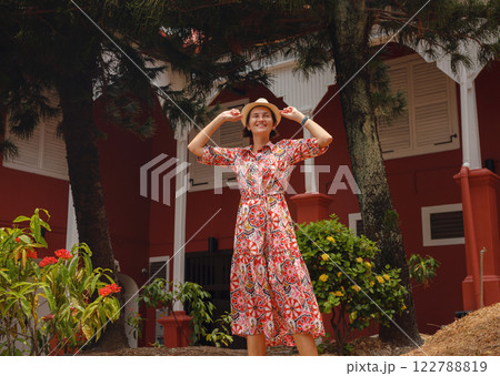 woman in dress and hat exploring vibrant streets of Malacca, Malaysia. 122788819