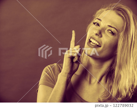 Happy woman pointing up with finger 122789032