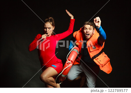 Lifeguards in life vest with ring buoy whistling. 122789577