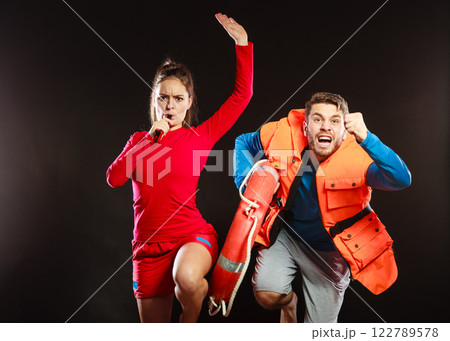 Lifeguards in life vest with ring buoy whistling. 122789578
