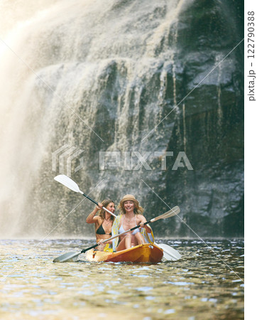 Kayak, summer and friends on river, nature and vacation adventure together in bikini swimsuit. Holiday, waterfall and freedom with young happy women rowing in a canoeing boat travel activity 122790388