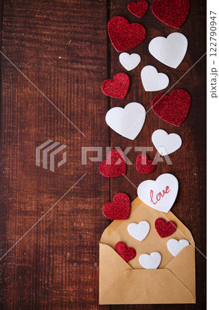 An envelope with an envelope and hearts on a wooden background 122790947