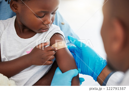 Doctor, healthcare expert and medical worker with plaster on arm of sick child after covid vaccine, help with medical emergency and consulting with patient at hospital. Girl with bandage after injury 122791387