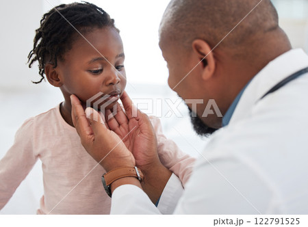 Medical doctor checking a girl throat with care in his office at a modern surgery center. Man pediatrician touching the patients neck during healthcare, medicare and illness consultation at clinic Medical doctor checking a girl throat with care in his office at a modern surgery center. Man pediatrician touching the patients neck during healthcare, medicare and illness consultation at clinic 122791525