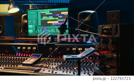 Music recording studio control room with daw software used to mix and master audio tracks, empty soundproof professional space. Modern sliders on control panel board to edit sound waves. 122791723