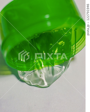 Aloe vera gel close-up, in bright green container on a white surface. High quality photo 122791946