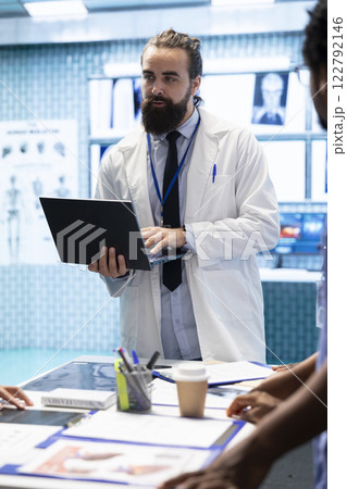 Healthcare professionals attending a strategy meeting in a medical center, focusing on treatment plans for disease prevention. General practitioner exploring healthcare improvement initiatives. 122792146