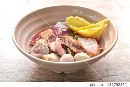 boiled fish ball with dumpling topping slice pickled squid and morning glory in red sauce soup on bowl boiled fish ball with dumpling topping slice pickled squid and morning glory in red sauce soup on bowl 122792822