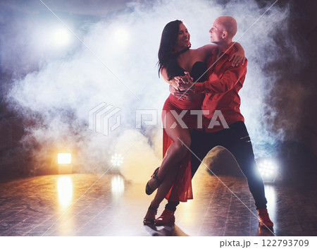 Skillful dancers performing in the dark room under the concert light and smoke. Sensual couple performing an artistic and emotional contemporary dance 122793709