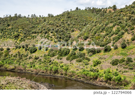 A train going alongside the Barca da Amieira walkways in Amieira do Tejo, Portugal. 122794066