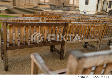 A modern wooden benches standing in the park. Comfortable bench in recreation area. City improvement, urban planning, public spaces. 122794454