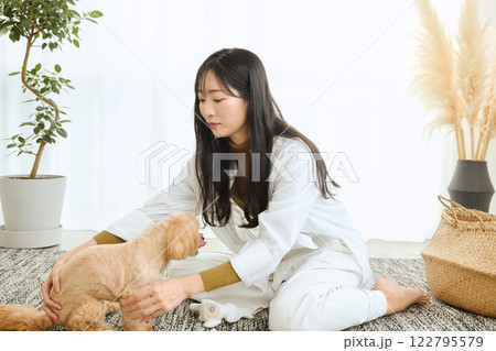 リビングで愛犬と遊ぶ女性 122795579