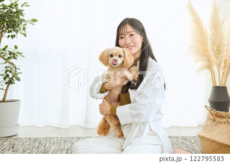 リビングで愛犬と遊ぶ女性 122795583