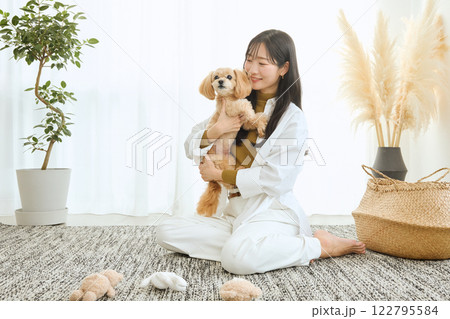 リビングで愛犬と遊ぶ女性 122795584