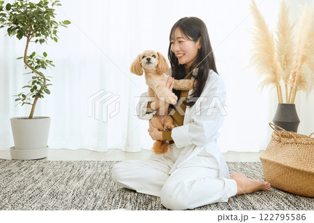 リビングで愛犬と遊ぶ女性 122795586