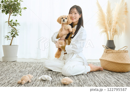 リビングで愛犬と遊ぶ女性 122795587
