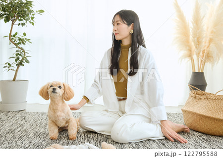 リビングで愛犬と遊ぶ女性 122795588