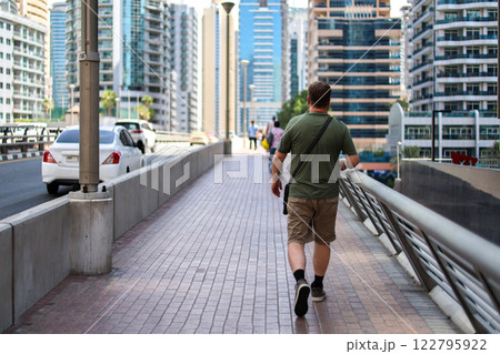 A large adult man walks through the city, rear view A large adult man walks through the city, rear view 122795922
