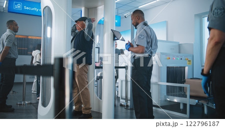 TSA Security Line in Airport: Elderly Woman and Man Walking Through Metal Detector Scanner TSA Security Line in Airport: Elderly Woman and Man Walking Through Metal Detector Scanner 122796187