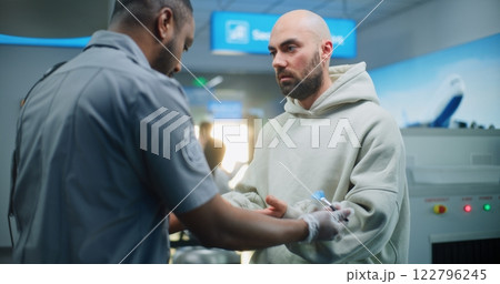 Airport Terminal: Security Officer Conducts TSA Hand Swab Screening to Male Passenger for Flight Airport Terminal: Security Officer Conducts TSA Hand Swab Screening to Male Passenger for Flight 122796245