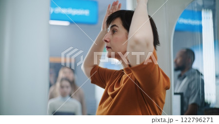 Airport Terminal: Diverse Passengers Passing Through X-ray Metal Detector Scanner Gates 122796271