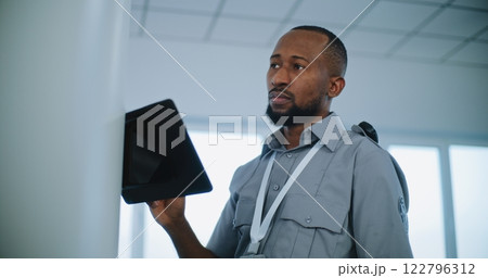Close Up of Security Officer Controlling Passengers Scanning for Plane Flight, Using Tablet Computer 122796312