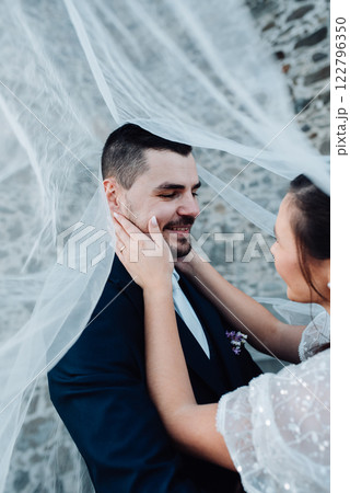 Portrait of beautiful bride and groom under the veil. Portrait of beautiful bride and groom under the veil. 122796350