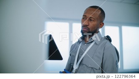 Close Up of Security Officer Controlling Passengers Scanning for Plane Flight, Using Tablet Computer 122796364