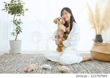 リビングで愛犬と遊ぶ女性 122797069