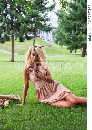 Beauty blonde young woman resting in the park Beauty blonde young woman resting in the park 122797561