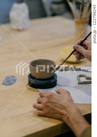 Close-up of a ceramic cup in progress, showing precise craftsmanship. Pottery student learns sculpting techniques, modeling a unique handmade cup 122798243