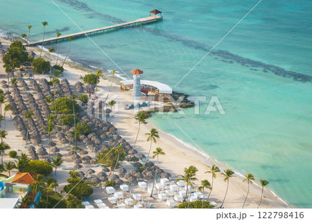Top view of a Bayahibe beach with parasol lighthouse and pier in the Dominican Republic Top view of a Bayahibe beach with parasol lighthouse and pier in the Dominican Republic 122798416