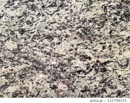 Natural granite surface showcasing intricate patterns and textures in neutral tones 122799335