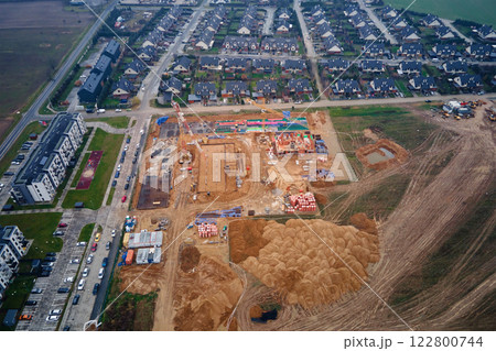Construction site with cranes building new houses 122800744