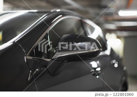 Rear view mirror of modern sedan in dimly lit underground parking garage, highlighting sleek design and automotive details. Rear view mirror of modern sedan in dimly lit underground parking garage, highlighting sleek design and automotive details. 122801060