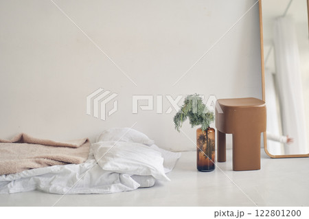 The interior was shot in a modern white loft with a bed on the floor. A part of the mirror on the floor with a reflection of the room. An empty wall for your design. High quality photo 122801200